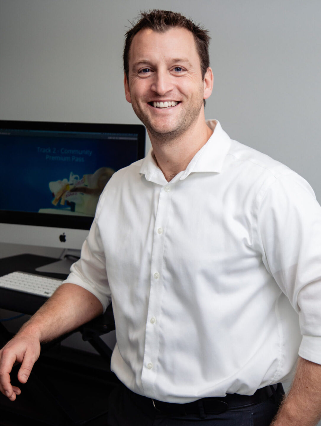 Peter-1365x2048 Peter McLeod standing by desk with white shirt on .